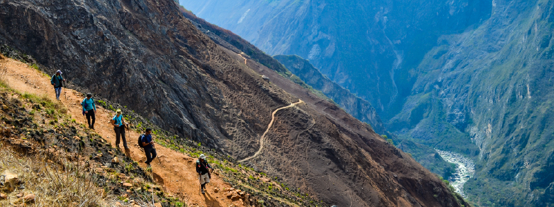 Traveler admiring Machu Picchu ruins at sunrise during a guided tour